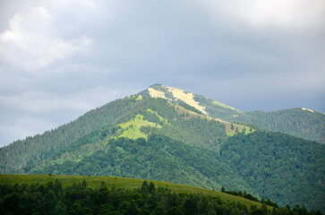 Colorful scenery of carpathian mountains with peak of mount Strymba in the distance beneath a cloudy sky. Popular travel destination. Carpathians, Ukraine 