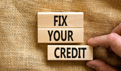 Fix your credit symbol. Concept words Fix your credit on wooden blocks on a beautiful canvas table canvas background. Businessman hand. Business, finacial and fix your credit concept. Copy space.