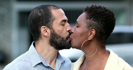 Interracial couple kissing each other, African wife and hispanic husband kiss outside