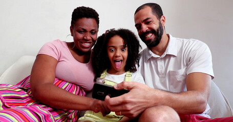 Interracial couple and mixed race daughter posing for photo on cellphone
