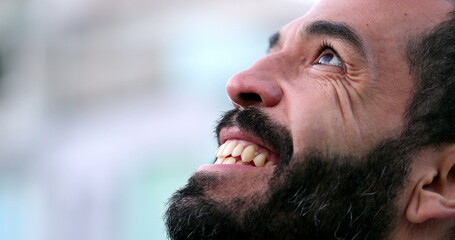 Obraz premium Hopeful man in 40s opening eyes to sky with FAITH, close-up face eye open