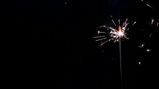 A Full HD Slow motion video of a sparkler burning and sparking isolated on a black background with copy space. perfect for event or birthday or e-vite 