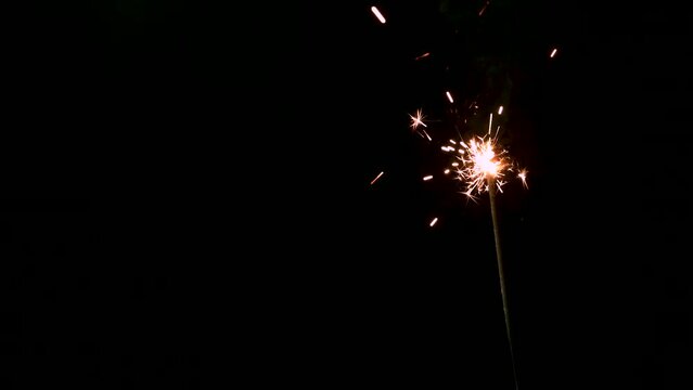 A Full HD Slow motion video of a sparkler burning and sparking isolated on a black background with copy space. perfect for event or birthday or e-vite 