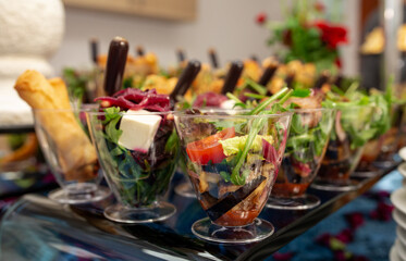 salads and snacks in plastic cups on the buffet