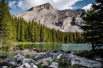 Up in the alpine a beautiful blue mountain lake feeds a stream with cold refreshing glacier water....