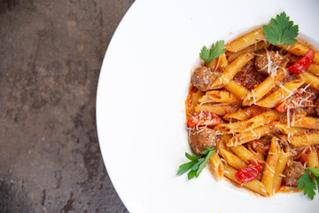 pasta with herbs in a white plate close-up.