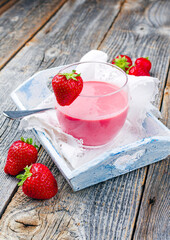 Traditionelle deutsche Erdbeere mit hausgemachtem Erdbeerquark serviert in einem Glas als close-up auf einem Shabby Chic Holz Tablett