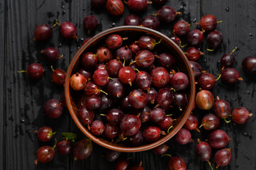 Ripe agrus or gooseberry on a dark wooden background.