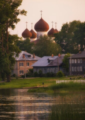 wooden houses against the backdrop of a church near the Onega River in the ancient city of Kargopol