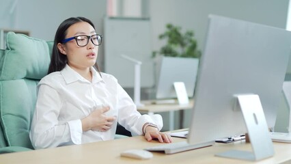 young asian female office worker having panic attack at workplace. business woman employee in the office shortness of breath, tired and sick having severe chest pain heartache at work indoor. Asia