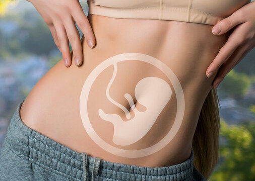 The body of a woman in perfect shape with the image of a child on her stomach. pregnancy concept. nature background