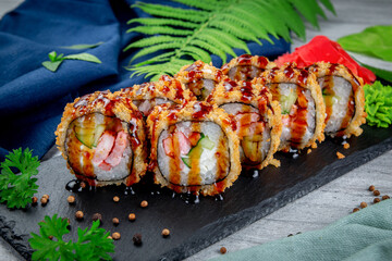 Fried tempura sushi rolls with shrimp, cream cheese, gherkin in batter. Traditional Japanese Cuisine