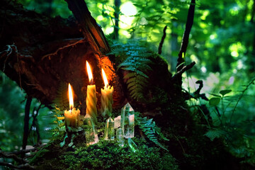 Clear Rhinestones and candles in mysterious forest, blurred dark natural background. Witchcraft,...