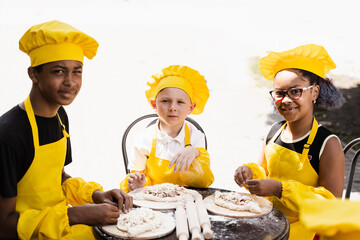 Childhood cook activity of multinational children of black african and caucasian kids in yellow...