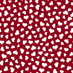 Seamless scattered white hearts in various sizes on red background