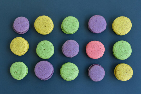 Top view of multicolored macaroons on grey background. 