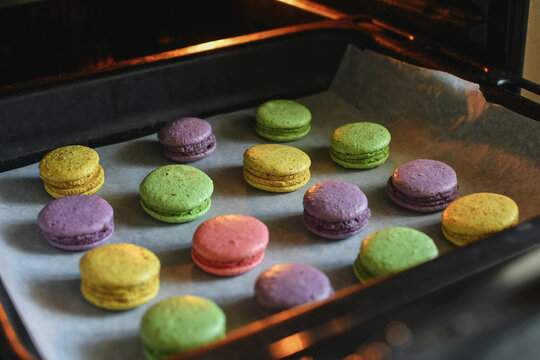Tray with multicolored macaroons in the oven. Selective focus. 