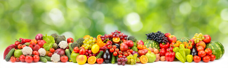 Bright multi-colored berries, fruits and vegetables on green