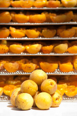Apricots and apricot slices ready for drying in the drying chamber. Many apricot slices lie on the shelves in the drying chamber and juicy apricots. Dried fruit
