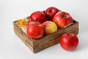 apples in a decorative box lined with wood shavings on a white background