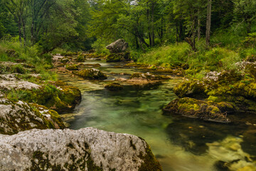 Fototapeta na wymiar Mostnica small river with color surroundings in Slovenia mountains