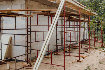 Fototapeta na wymiar Wood modern and classic tools on newly building house construction with new roof structure , water pipes and scaffolding around building