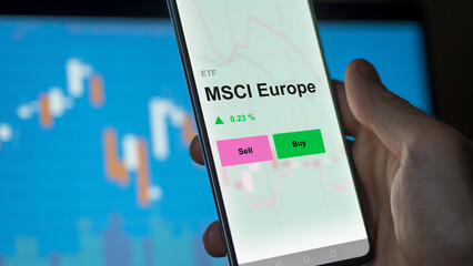 An investor's analizing the msci europe etf fund on a screen. A phone shows the prices of MSCI Europe