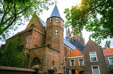 Fototapeta premium Narrow street and Oude Kerk tower in old beautiful city Delft, Netherlands