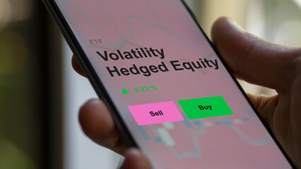 An investor's analizing the volatility hedged equity etf fund on a screen to invest. A phone shows the prices of volatility-hedged equities