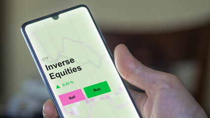 Un investisseur analyse le fonds ETF d'actions inversées sur un écran. Un téléphone affiche les...