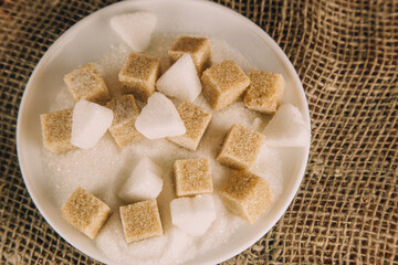 sugar cubes on black backround. Sugar is unhealthy nutrition and leads to obesity, diabetes, dental care