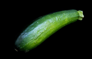 green zucchini lies on a black background