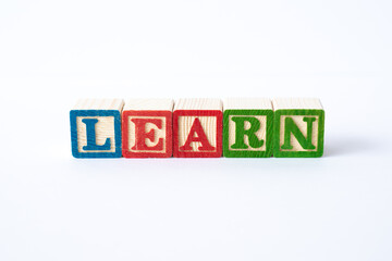 The word Learn spelled with colorful toy blocks on a white background