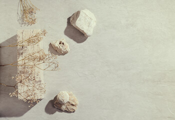 Flatlay minimal natural stone, marble or travertino surface background with stones and dry flowers. Template for showcase, presentations, branding, web desing, posts.