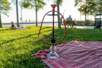 hookah in the park on picnic blanket, sunset background.