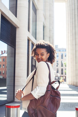 young pretty african girl posing cheerful on city background, lifestyle outdoor people concept