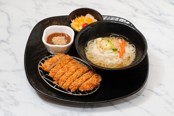 Korean Banquet Noodles and pork cutlet set on bright background.