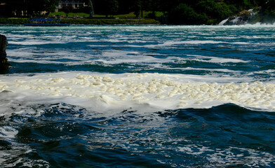 Selective focus picture with noise effect of river foam at Rhine Falls river. Foam can be formed...