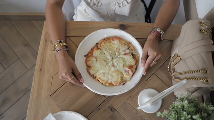 vista desde arriba de una joven en restaurante con pizza vegana con tomate y queso mozzarella sobre...