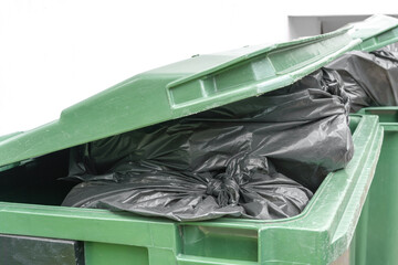 green bin full of garbage bag