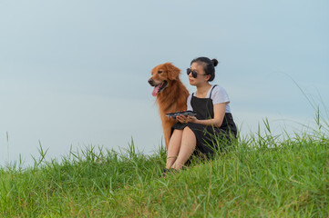 Golden Retriever sits on grass with owner