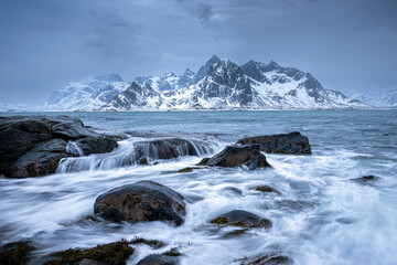 Winter landscape of sea shore and mountains in background
