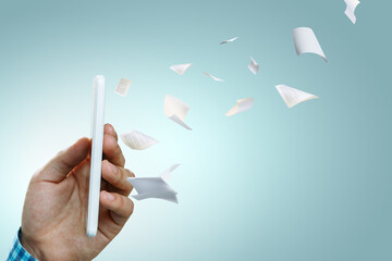 Hand holding smart mobile phone and paper flying away