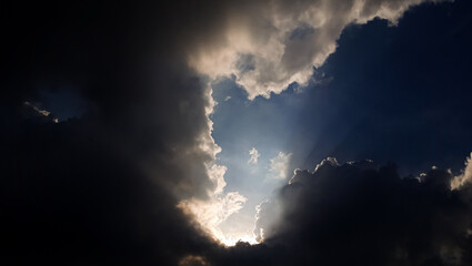 Dramatic sky with clouds. Bright sun rays through dark sky.  