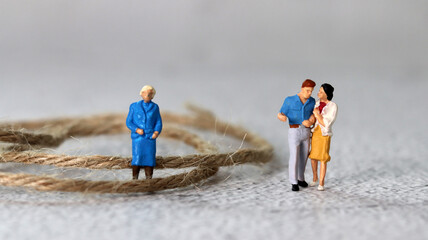 Miniature people standing with rope. The concept of conflict between mother-in-law and...