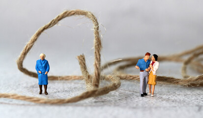 Miniature people standing with rope. The concept of conflict between mother-in-law and...