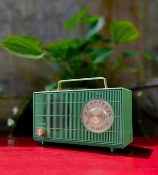 vintage 60's green transistor radio on red table