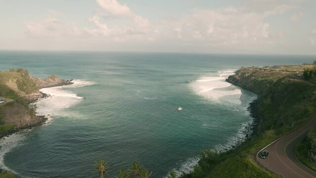 aerial floating out to sea over Honokohau Bay, Maui, Hawaii.  Long, flowing waves seem to drift in from distant shores in the Pacific Ocean.  A popular coastal tourist destination.