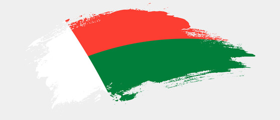 National flag of Madagascar with curve stain brush stroke effect on white background - obrazy, fototapety, plakaty