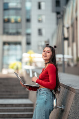 Beautiful young woman on the street using laptop